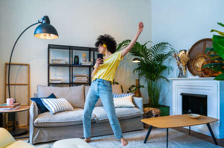 Beautiful latino young woman at home - Pretty south american with curly hair female portrait, lifestyle and domestic life sceneの写真素材