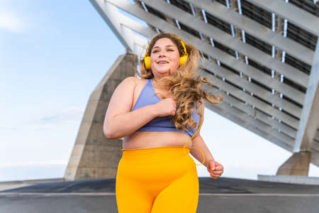 Beautiful and cheerful plus size young woman outdoors - Pretty overweight curvy female, concepts about femininity, women power, female emancipation, body positivity and body acceptanceの写真素材