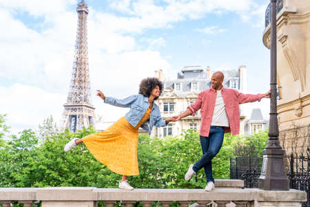 Black cheerful happy couple in love visiting Paris city center and Eiffel Tower - African american tourists traveling in Europe and dating outdoorsの写真素材
