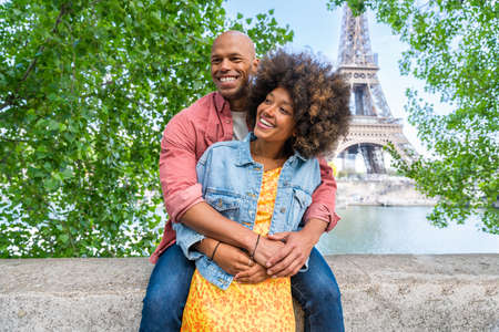Black cheerful happy couple in love visiting Paris city center and Eiffel Tower - African american tourists traveling in Europe and dating outdoorsの写真素材