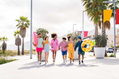 Multiethnic group of young happy friends bonding outside, having fun on summertime vacation -...