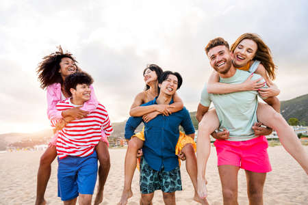 Multiethnic group of young happy friends bonding outside, having fun on summertime vacation -...
