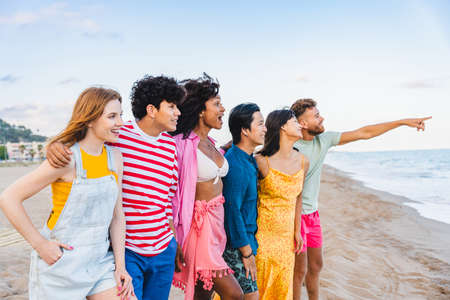 Multiethnic group of young happy friends bonding outside, having fun on summertime vacation -...