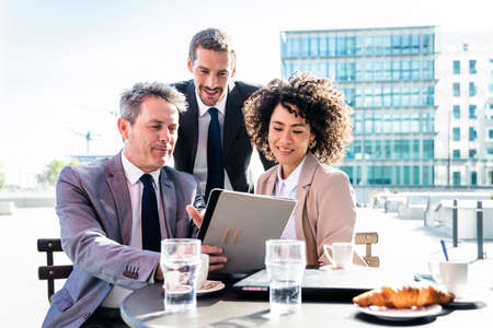 Senior businessman, caucasian man and beautiful hispanic businesswoman meeting in a bar restaurant -...
