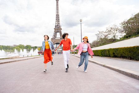 Group of young happy friends visiting Paris and Eiffel Tower, Trocadero area and Seine river - Multicultural group of tourists sightseeing the France capital cityの写真素材