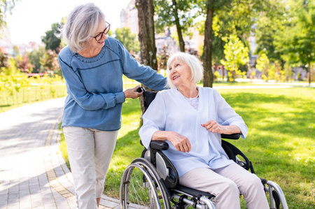 Beautiful senior women with disability outdoors - Old people in the age of 60, 70, 80 having fun and...
