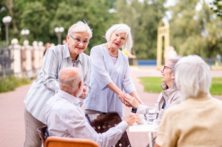Group of happy elderly people bonding outdoors at the bar cafeteria - Old people in the age of 60,...