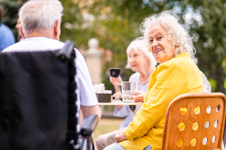 Group of happy elderly people bonding outdoors at the bar cafeteria - Old people in the age of 60, 70, 80 having fun and spending time together, concepts about elderly, seniority and wellness agingの写真素材