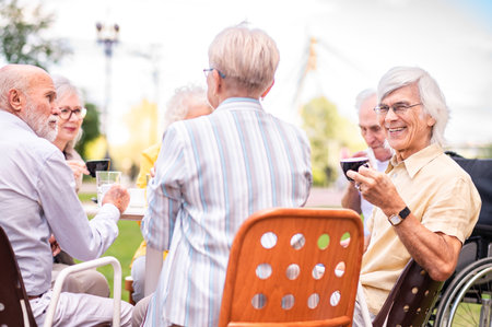Group of happy elderly people bonding outdoors at the bar cafeteria - Old people in the age of 60, 70, 80 having fun and spending time together, concepts about elderly, seniority and wellness agingの写真素材
