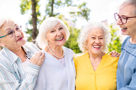 Group of happy elderly people bonding outdoors at the park - Old people in the age of 60, 70, 80 having fun and spending time together, concepts about elderly, seniority and wellness agingの写真素材