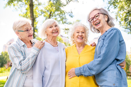 Group of happy elderly people bonding outdoors at the park - Old people in the age of 60, 70, 80 having fun and spending time together, concepts about elderly, seniority and wellness agingの写真素材