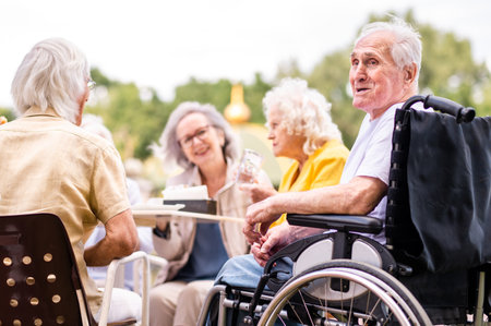 Group of happy elderly people bonding outdoors at the bar cafeteria - Old people in the age of 60, 70, 80 having fun and spending time together, concepts about elderly, seniority and wellness agingの写真素材
