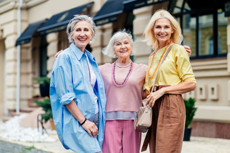 Beautiful happy senior women meeting outdoors and shopping in the city center - Pretty and joyful old female adult people bonding and having fun outdoorsの写真素材