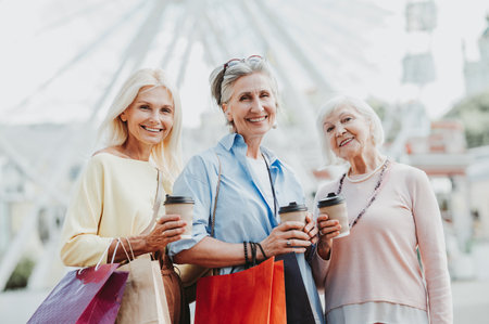 Beautiful happy senior women meeting outdoors and shopping in the city center - Pretty and joyful old female adult people bonding and having fun outdoorsの写真素材