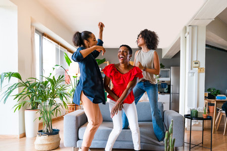 Happy beautiful hispanic south american and black women meeting indoors and having fun - Black adult females best friends spending time together, concepts about domestic life, leisure, friendship and togethernessの写真素材