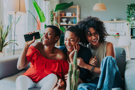 Happy beautiful hispanic south american and black women meeting indoors and having fun - Black adult females best friends spending time together, concepts about domestic life, leisure, friendship and togethernessの写真素材