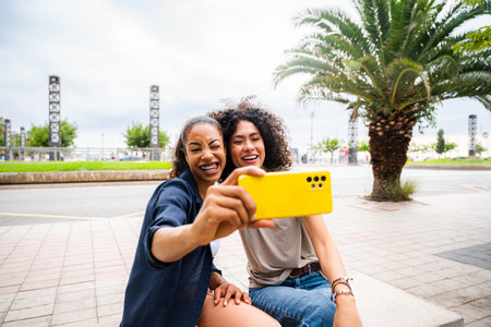 Happy beautiful hispanic south american women meeting outdoors and having fun - Black adult females friends spending time togetherの写真素材