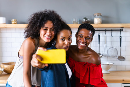 Happy beautiful hispanic south american and black women meeting indoors and having fun - Black adult females best friends spending time together, concepts about domestic life, leisure, friendship and togethernessの写真素材
