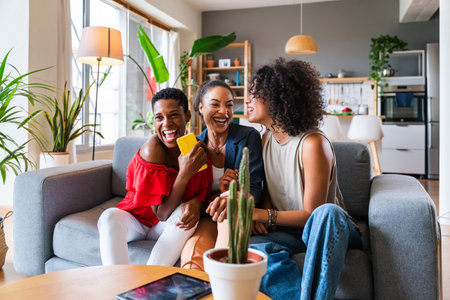 Happy beautiful hispanic south american and black women meeting indoors and having fun - Black adult females best friends spending time together, concepts about domestic life, leisure, friendship and togethernessの写真素材