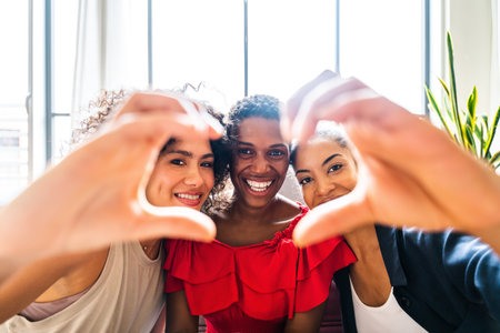 Happy beautiful hispanic south american and black women meeting indoors and having fun - Black adult females best friends spending time together, concepts about domestic life, leisure, friendship and togethernessの写真素材