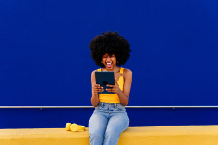 Beautiful young happy african woman with afro curly hairstyle strolling in the city - Cheerful black...