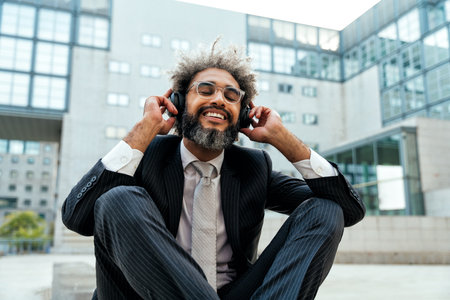 Young entrepreneur business man listening to music and dancing outside the office. Concept about...