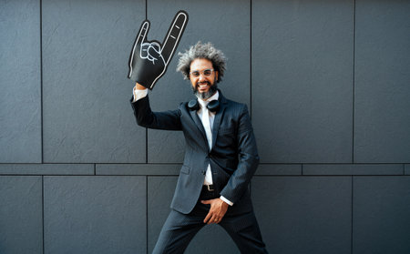 Cinematic and storytelling image of a young entrepreneur celebrating and going wild with big hands gesturing hornsの写真素材