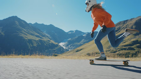 Cinematic downhill longboard session. Young woman skateboarding and making tricks between the curves on a mountain pass. Concept about extreme sports and peopleの写真素材
