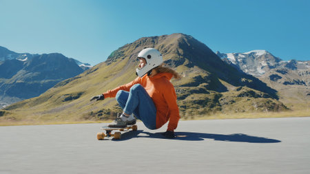 Cinematic downhill longboard session. Young woman skateboarding and making tricks between the curves on a mountain pass. Concept about extreme sports and peopleの写真素材