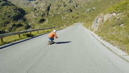 Cinematic downhill longboard session. Young woman skateboarding and making tricks between the curves on a mountain pass. Concept about extreme sports and peopleの写真素材