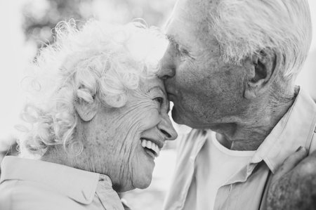 Old modern couple dressing fashionable colored clothes. Youthful grandmother and grandfather having fun outdoor and going wild. Representation of elderly people feeling young insideの写真素材