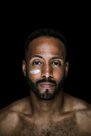 Image of a young man taking care of his skin. Beauty studio shot about skin care and products for the personal hygiene.の写真素材