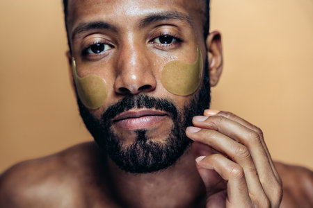 Image of a young man taking care of his skin. Beauty studio shot about skin care and products for the personal hygiene.の写真素材