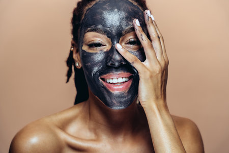 Beautiful woman making skin and facial beauty treatments. Studio shot with focus on cosmetic and skin care conceptsの写真素材