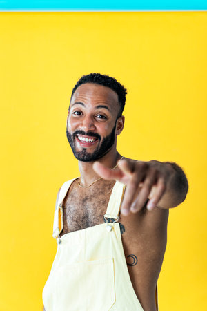 Image of a handsome young man posing on colored backgrounds wearing colorful trendy clothes. Concept about carefree, fashion and lifestyleの写真素材