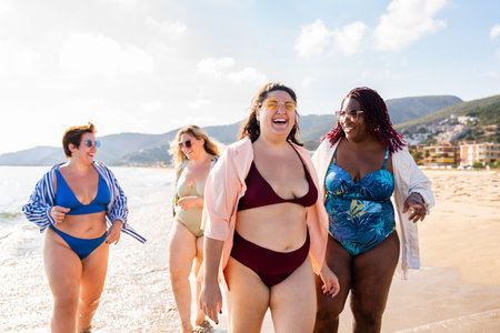 Group of beautiful plus size women with swimwear bonding and having fun at the beach - Group of curvy female friends enjoying summertime at the sea, concepts about body acceptance, body positive and self confidenceの写真素材