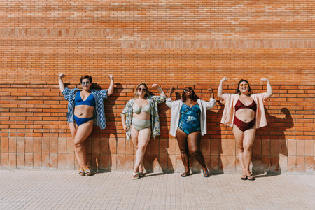 Group of beautiful plus size women with swimwear bonding and having fun at the beach, posing on a...