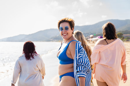 Group of beautiful plus size women with swimwear bonding and having fun at the beach - Group of curvy female friends enjoying summertime at the sea, concepts about body acceptance, body positive and self confidenceの写真素材