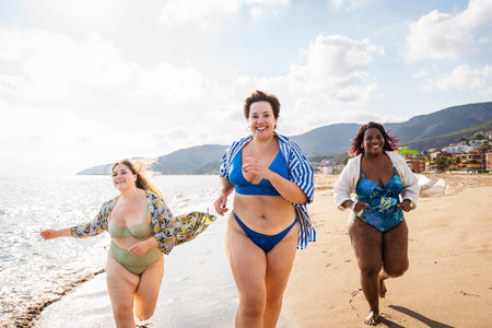 Group of beautiful plus size women with swimwear bonding and having fun at the beach - Group of curvy female friends enjoying summertime at the sea, concepts about body acceptance, body positive and self confidenceの写真素材