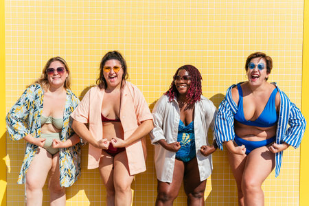 Group of beautiful plus size women with swimwear bonding and having fun at the beach - Group of curvy female friends enjoying summertime at the sea, concepts about body acceptance, body positive and self confidenceの写真素材