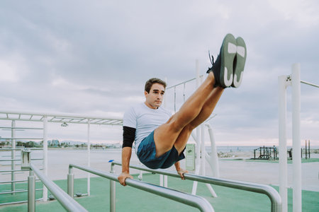 Sportive and athletic man doing functional training exercise at the outdoor gym - Adult athlete...