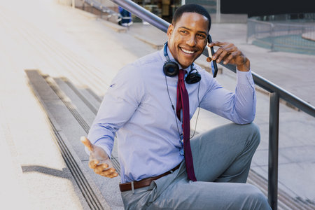 Handsome male african american business man CEO in a stylish corporate elegant suit in a business center outdoors - Black male commuter going to work, city and financial district in the backgroundの写真素材