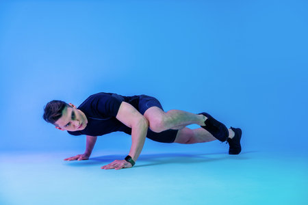 Athletic man with fit muscular body training in studio - Active man doing a workout, colorful...