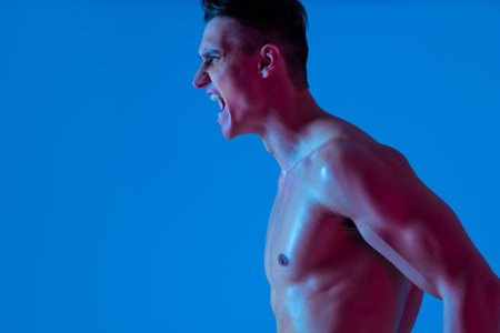 Athletic man with fit muscular body training in studio - Active man doing a workout, colorful...