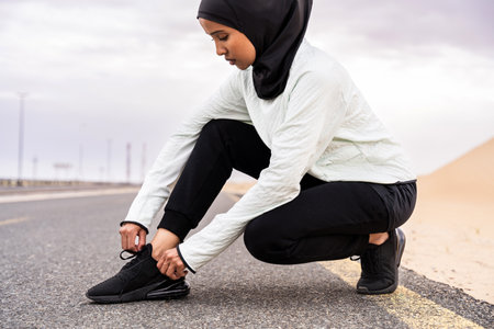 Beautiful middle-eastern arab woman wearing hijab training outdoors in a desert area - Sportive...