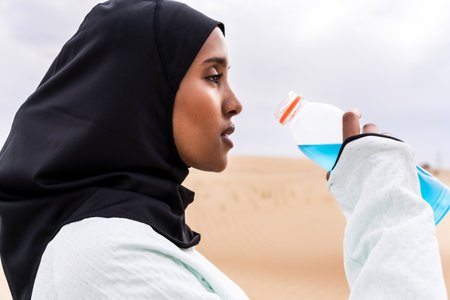 Beautiful middle-eastern arab woman wearing hijab training outdoors in a desert area - Sportive...