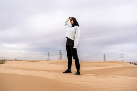 Beautiful middle-eastern arab woman wearing hijab training outdoors in a desert area - Sportive athletic muslim adult female wearing burkini sportswear doing fitness workoutの写真素材