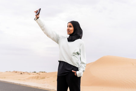 Beautiful middle-eastern arab woman wearing hijab training outdoors in a desert area - Sportive athletic muslim adult female wearing burkini sportswear doing fitness workoutの写真素材