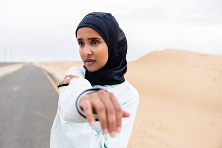 Beautiful middle-eastern arab woman wearing hijab training outdoors in a desert area - Sportive...