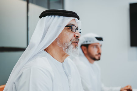 Group of middle-eastern corporate business people wearing traditional emirati clothes meeting in the...
